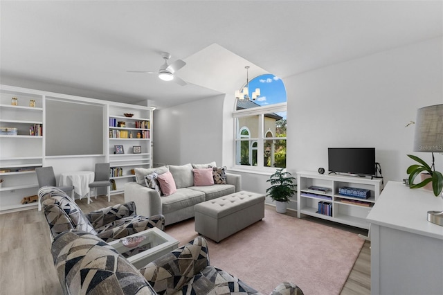 living room with wood finished floors and ceiling fan with notable chandelier