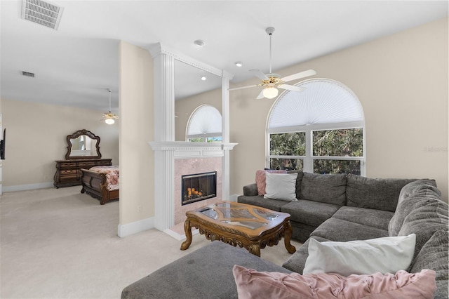 living room with light carpet, plenty of natural light, visible vents, and a ceiling fan