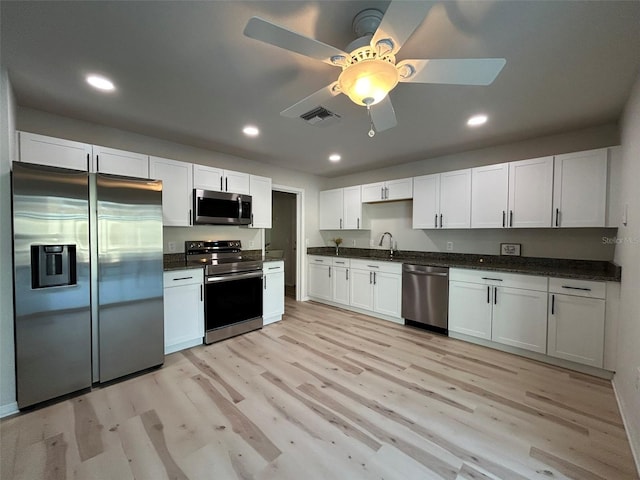 kitchen featuring visible vents, white cabinetry, recessed lighting, stainless steel appliances, and light wood-style floors