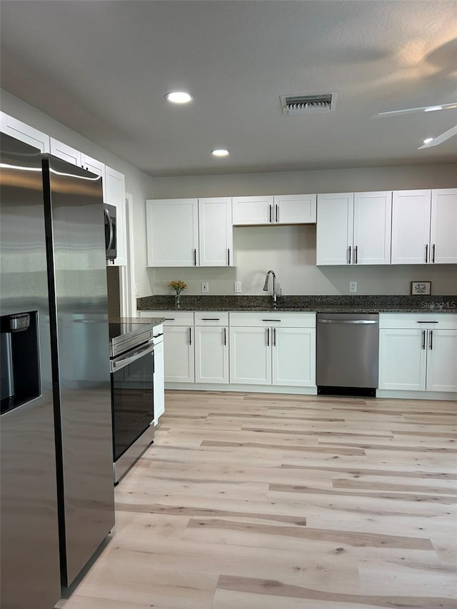 kitchen featuring light wood-type flooring, visible vents, white cabinetry, recessed lighting, and stainless steel appliances