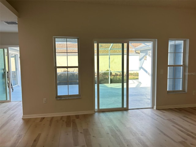 doorway with baseboards and light wood finished floors