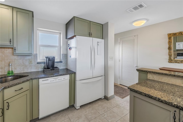 kitchen with tasteful backsplash, dark stone counters, white appliances, sink, and green cabinets