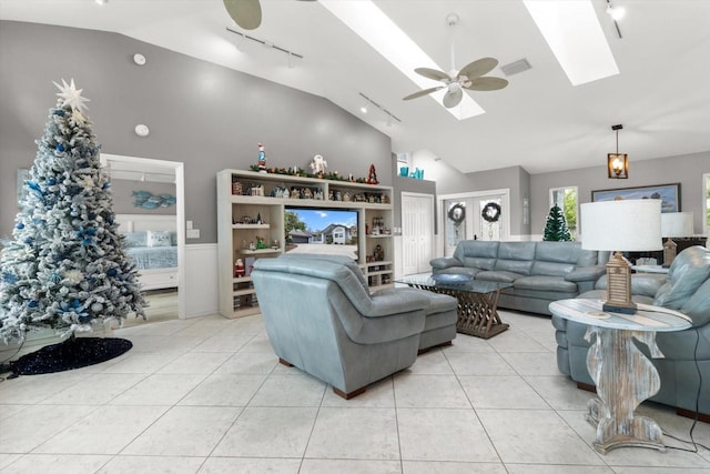 living room with french doors, rail lighting, a skylight, ceiling fan, and light tile patterned floors