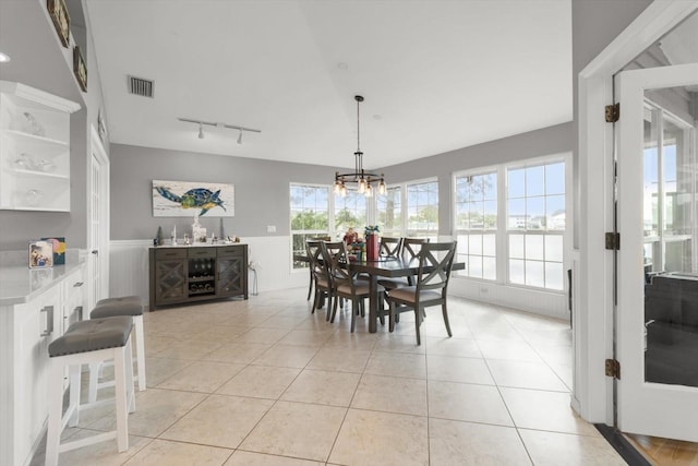 tiled dining space featuring track lighting