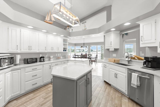 kitchen with a center island, white cabinets, stainless steel appliances, and sink