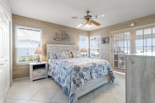 tiled bedroom with ceiling fan and a closet