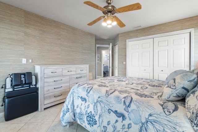 bedroom with ceiling fan, light tile patterned floors, and a closet