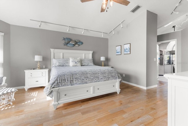 bedroom with ceiling fan, light hardwood / wood-style flooring, and rail lighting