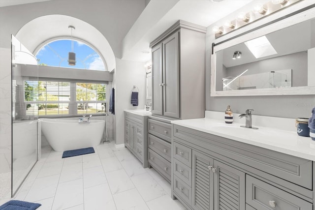 bathroom featuring separate shower and tub, vanity, and vaulted ceiling