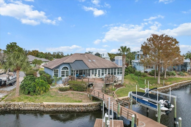 back of property featuring a yard and a deck with water view