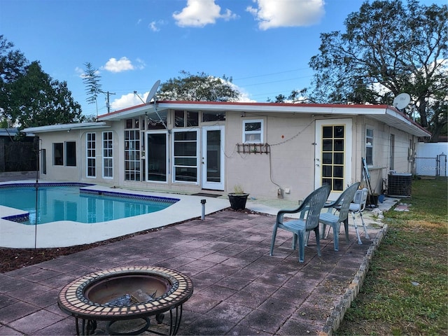 view of pool with a patio area, a fire pit, and central AC