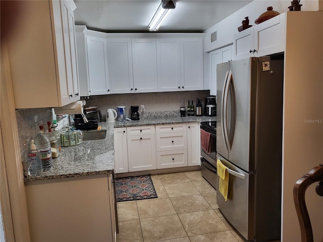 kitchen featuring white cabinets, light stone countertops, black range with electric stovetop, and stainless steel refrigerator