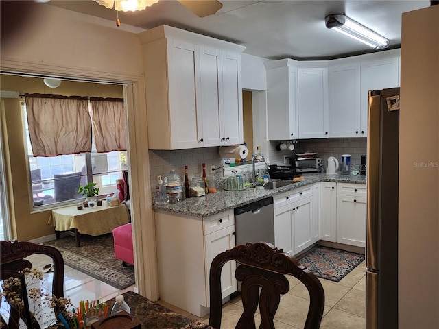 kitchen with decorative backsplash, white cabinetry, sink, and stainless steel appliances