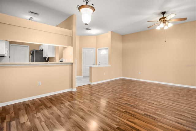 unfurnished living room with ceiling fan and light wood-type flooring