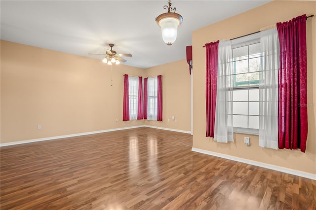 spare room featuring a wealth of natural light, hardwood / wood-style floors, and ceiling fan