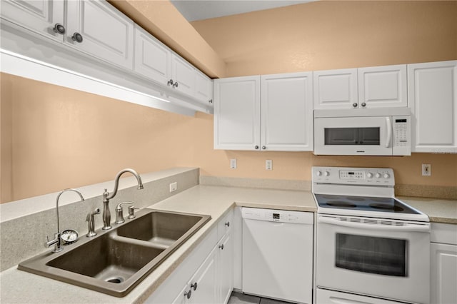 kitchen with white appliances, white cabinetry, and sink