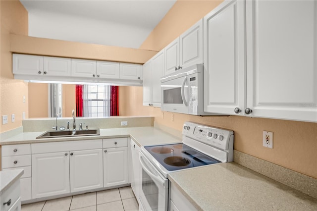 kitchen featuring sink, white cabinets, light tile patterned flooring, and white appliances