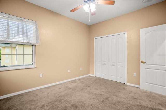 unfurnished bedroom with ceiling fan, carpet floors, and a closet