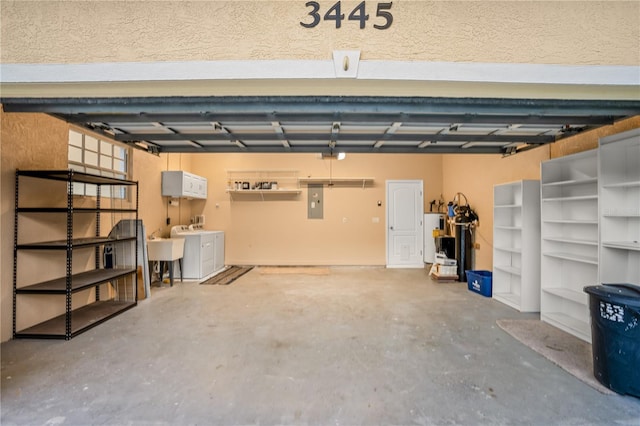 garage featuring electric water heater, electric panel, a garage door opener, and sink