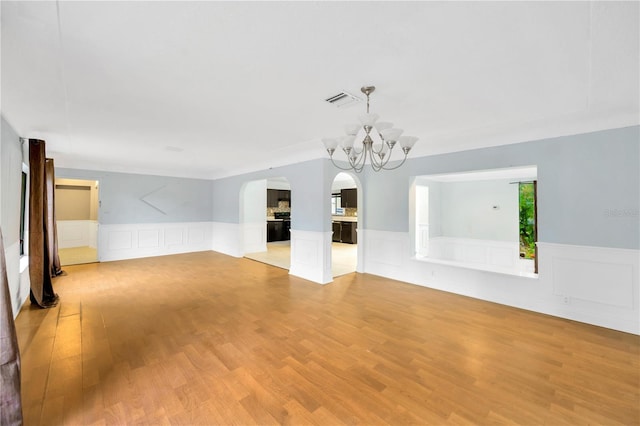 unfurnished room with light hardwood / wood-style floors and a notable chandelier