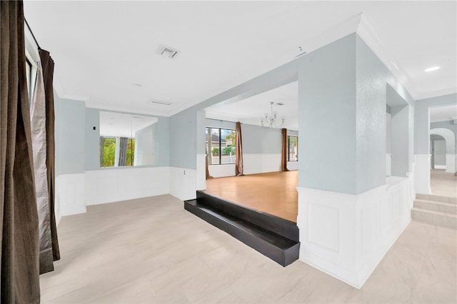 interior space featuring crown molding and a notable chandelier