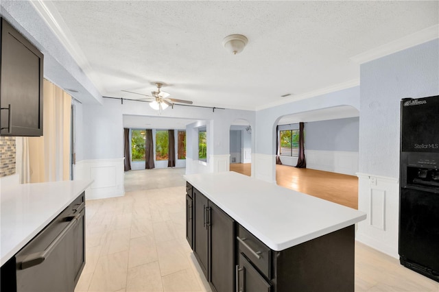 kitchen with black fridge with ice dispenser, a center island, plenty of natural light, and ceiling fan