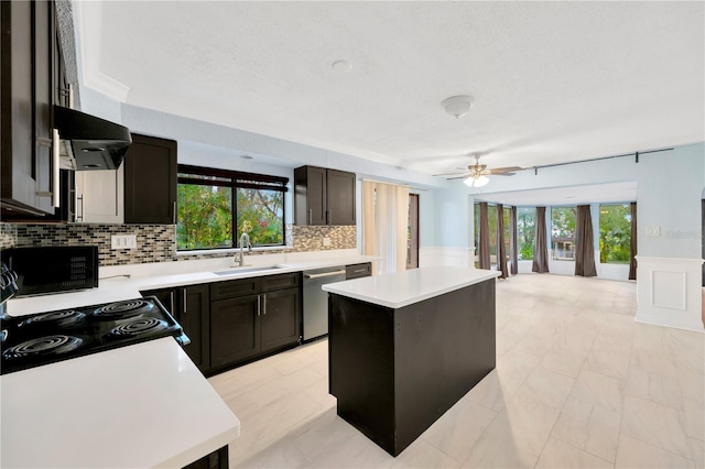 kitchen with sink, a kitchen island, stainless steel dishwasher, and plenty of natural light