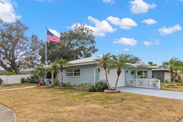 ranch-style home with covered porch, a garage, and a front lawn