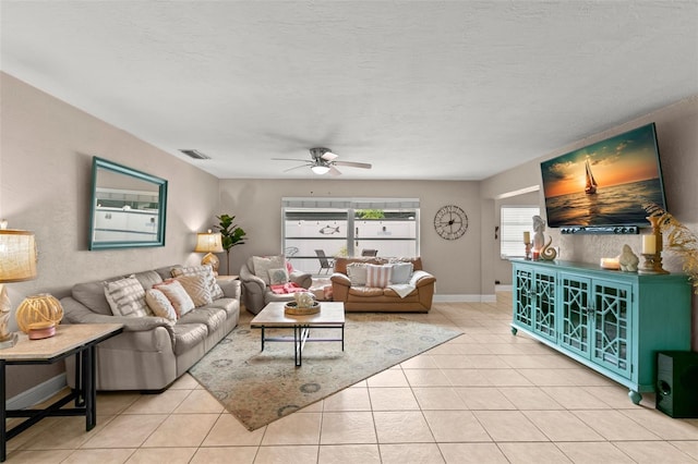 living room with light tile patterned floors, a textured ceiling, and ceiling fan