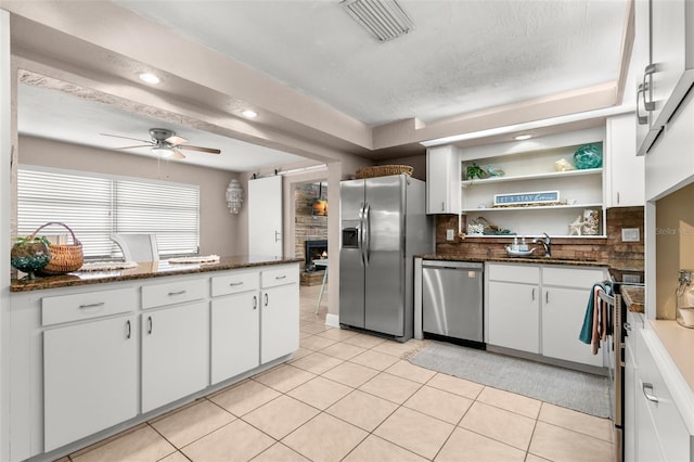 kitchen with white cabinetry, light tile patterned floors, stainless steel appliances, and ceiling fan