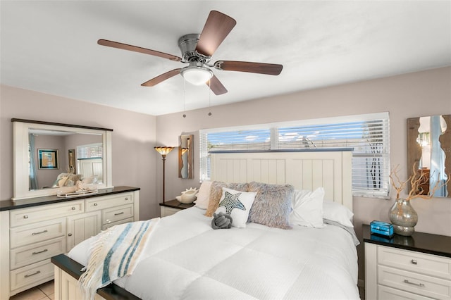 bedroom with multiple windows, ceiling fan, and light tile patterned floors