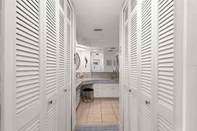 clothes washing area with light tile patterned floors