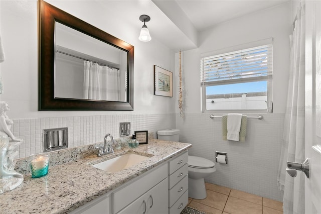 bathroom with tile patterned flooring, vanity, toilet, and tile walls