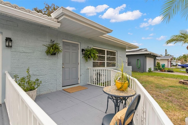 entrance to property featuring a lawn and covered porch