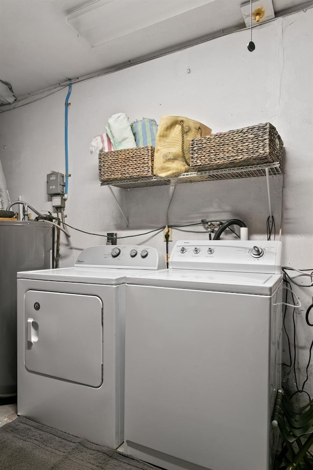 clothes washing area featuring separate washer and dryer and electric water heater