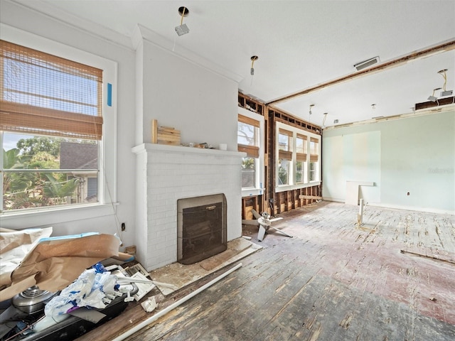 unfurnished living room with a brick fireplace and crown molding