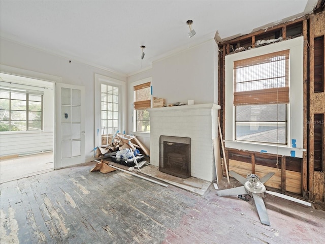 unfurnished living room featuring a brick fireplace and ornamental molding