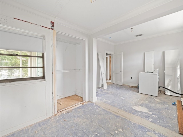 unfurnished bedroom with crown molding, washer / dryer, and a closet