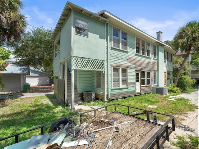 back of property with a lawn and central air condition unit