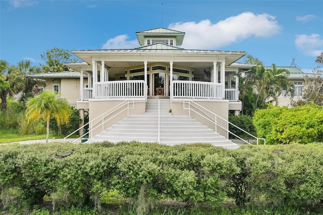 raised beach house featuring a porch