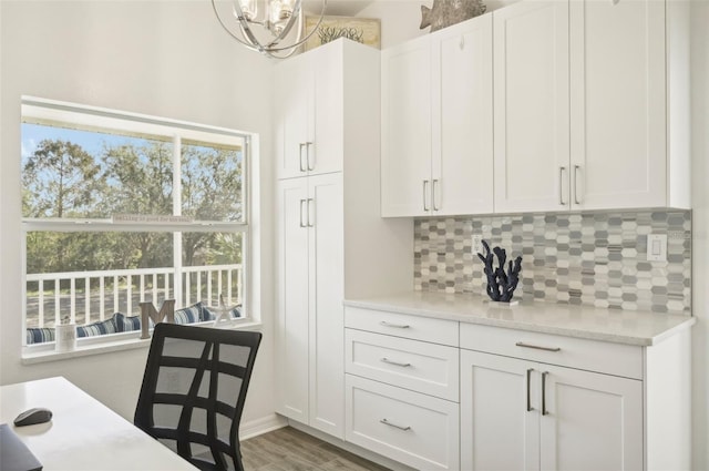 kitchen with tasteful backsplash, light stone countertops, white cabinets, and dark hardwood / wood-style floors