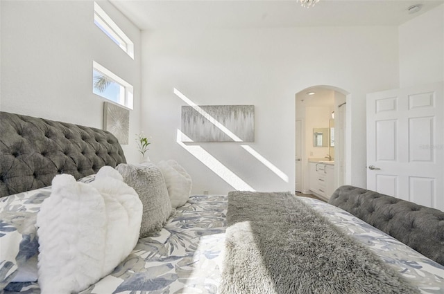 bedroom featuring a high ceiling and ensuite bath