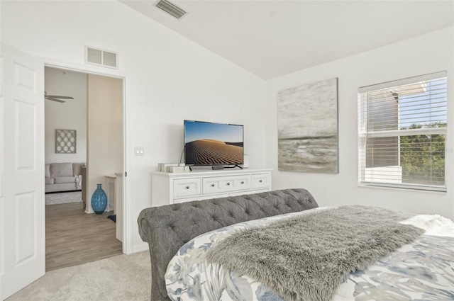 bedroom with light carpet and lofted ceiling