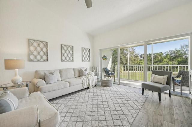 living room featuring ceiling fan, light hardwood / wood-style flooring, and high vaulted ceiling