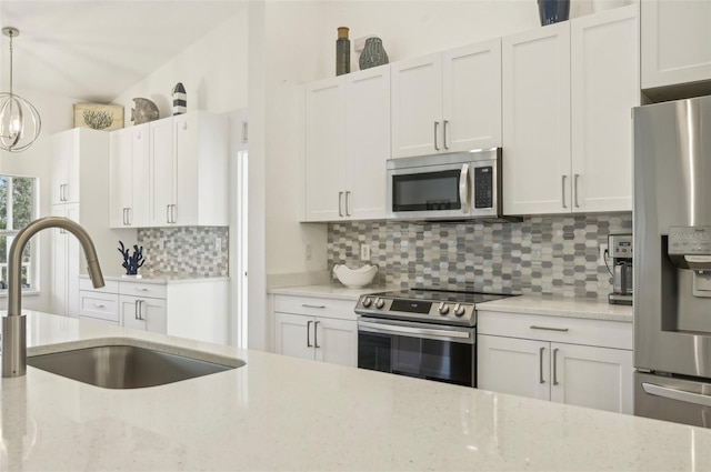 kitchen with backsplash, white cabinets, sink, decorative light fixtures, and stainless steel appliances