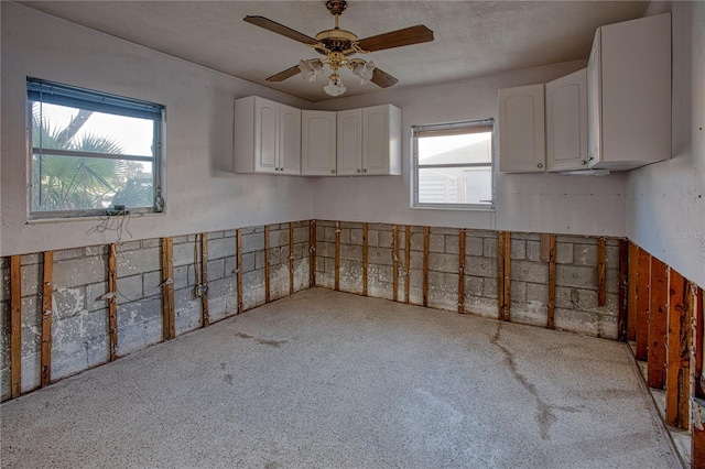 interior space featuring white cabinets and ceiling fan