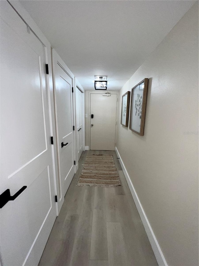 hallway with hardwood / wood-style flooring