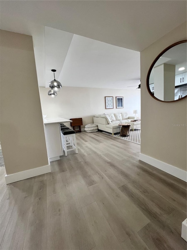 unfurnished living room with ceiling fan and light hardwood / wood-style flooring