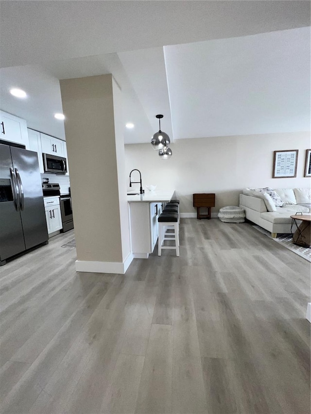 unfurnished living room featuring sink and light hardwood / wood-style flooring