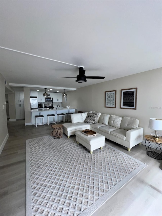 living room with hardwood / wood-style flooring and ceiling fan